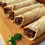 black bean air fryer taquitos on a wood cutting board and white tile background pinterest pin