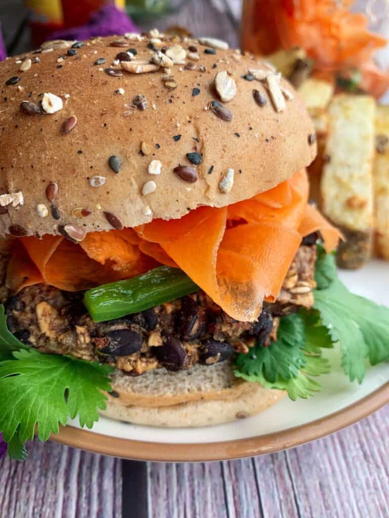 black bean bahn mi burgers with pickled veggies on a bun with a side of french fries