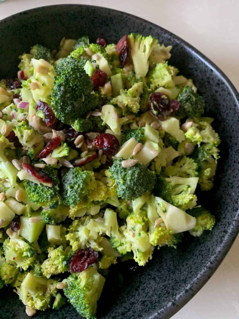 broccoli salad with maple mustard dressing in a black bowl