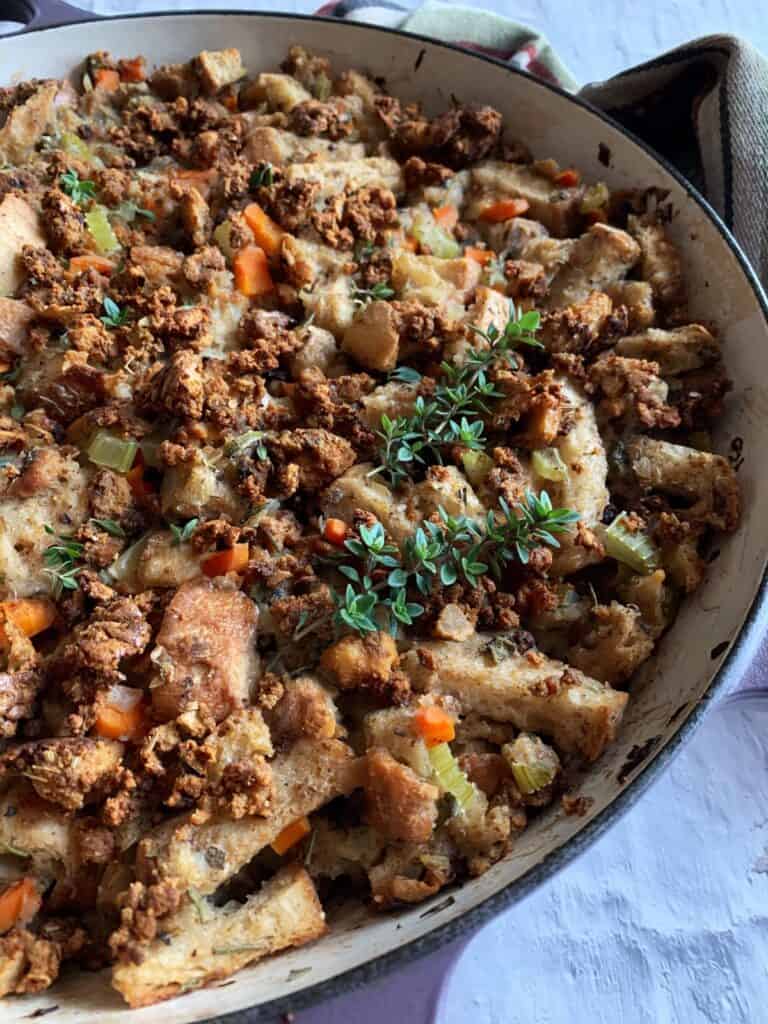 Healthy Vegan Stuffing with tofu sausage in a purple skillet on a white background