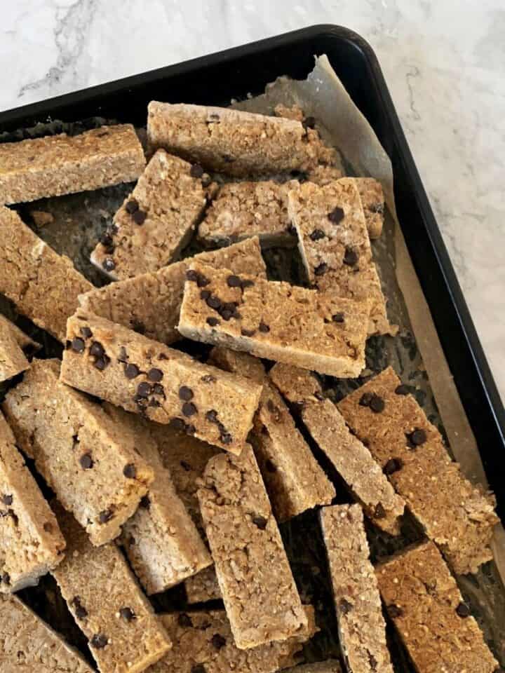 frozen chocolate chip oatie bars on a baking sheet with white background