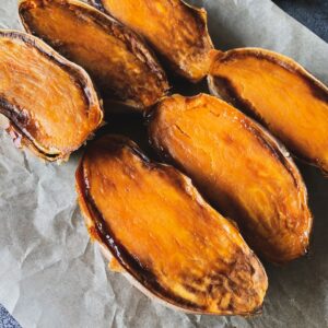 roasted sweet potatoes halved and caramelized on a sheet of parchment