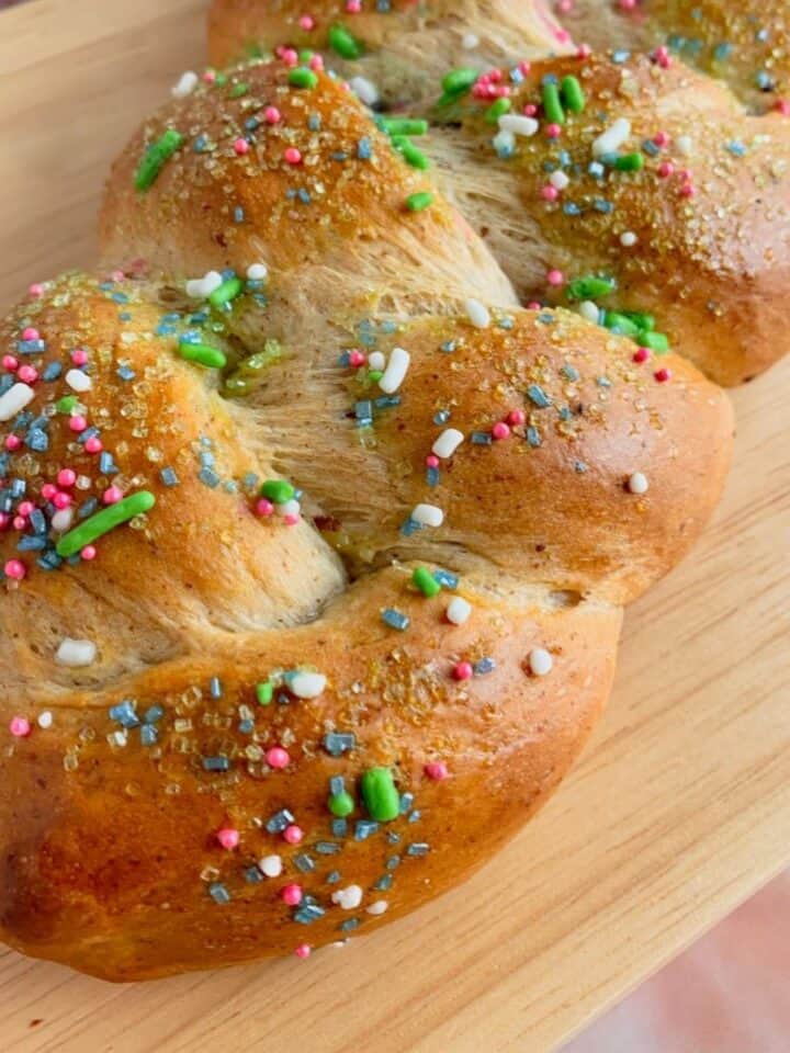 Vegan Braided Easter Bread on a cutting board with sprinkles