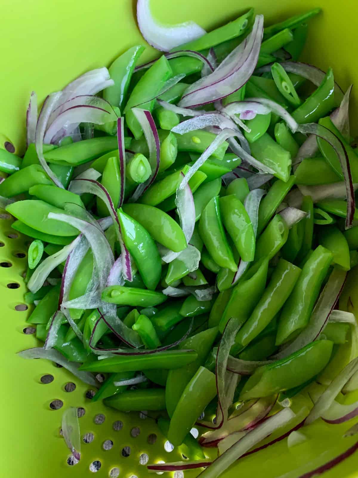 https://samcookskindness.com/wp-content/uploads/2022/06/drained-sugar-snap-peas-and-red-onions.jpg