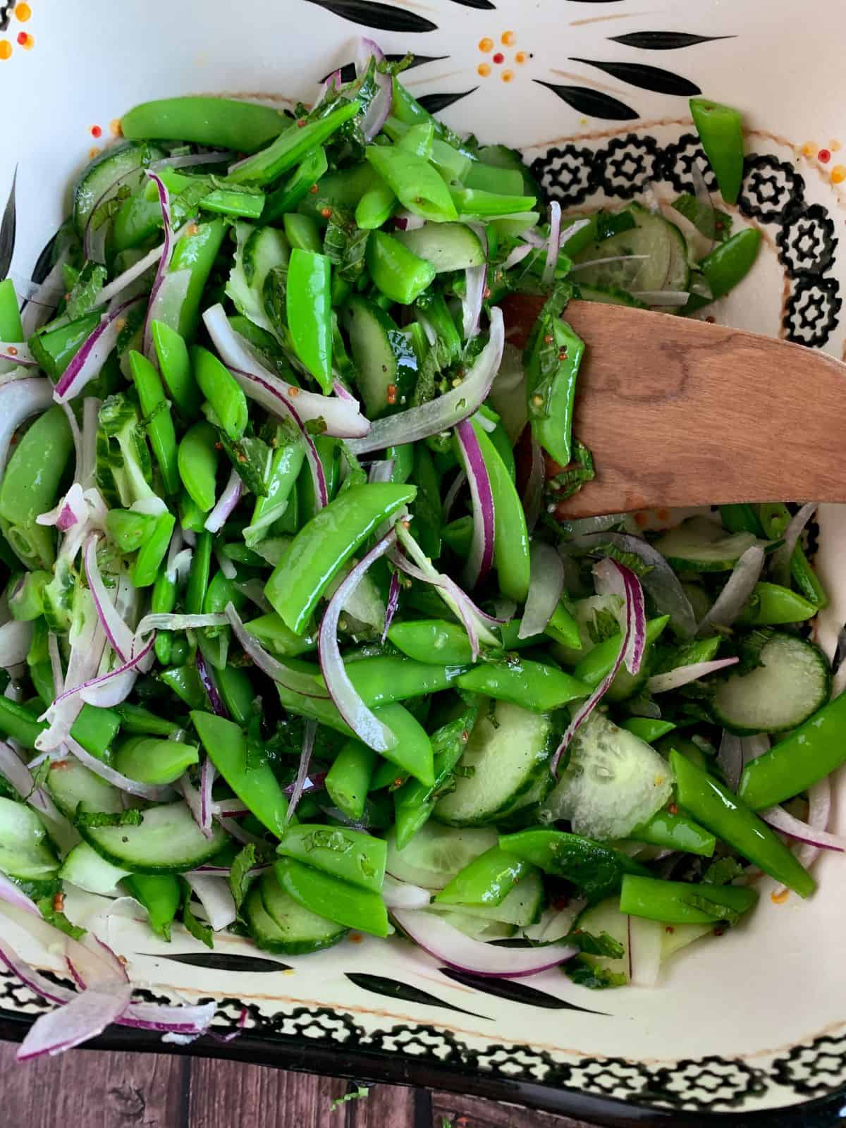 Sugar snap pea salad with shaved onion, radish, basil, and mint