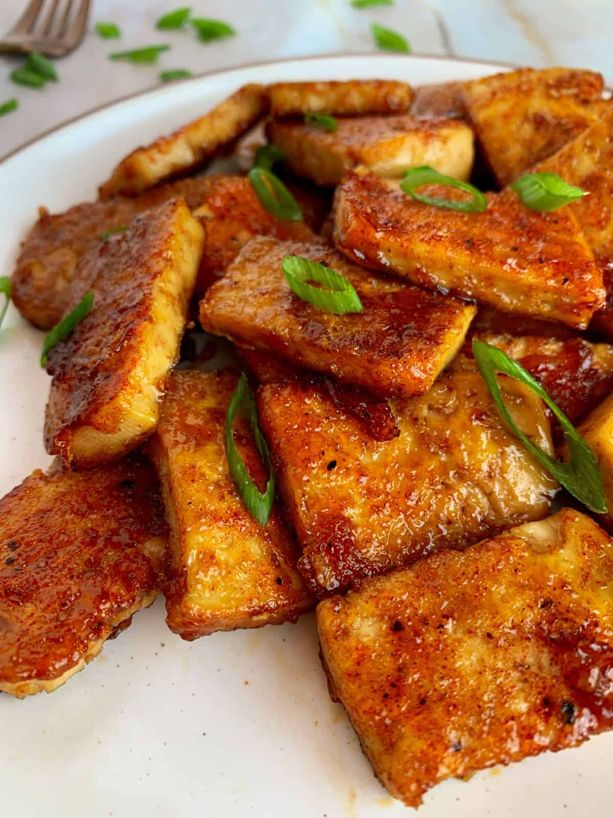 sweet and sticky tofu on a white plate