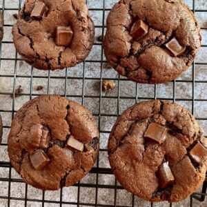 Close view of double chocolate cookies on a black wire cooling rack.