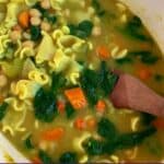 Pinterest image of chickpea noodle soup in a pot.