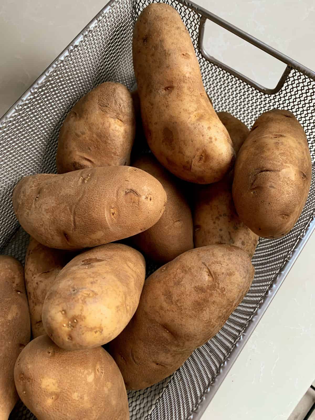 uncooked potatoes in a basket.