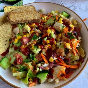 Chopped BBQ Salad topped with tortilla chips and crispy pickle tofu.