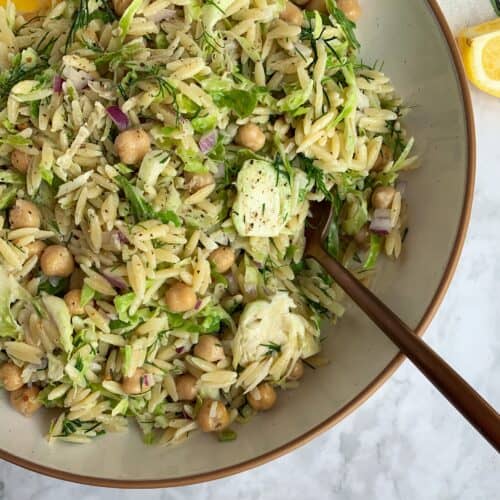 Lemon Dill Chickpea Orzo Salad in a white bowl with gold spoon.