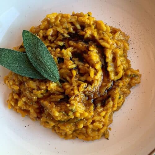 Vegan pumpkin risotto with sage and balsamic on a white plate.