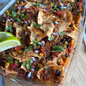Dump & go taco casserole in glass dish topped with cilantro and lime