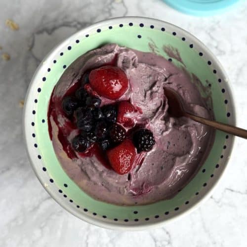 ninja creami chocolate berry breakfast ice cream in a bowl with cherries on top.