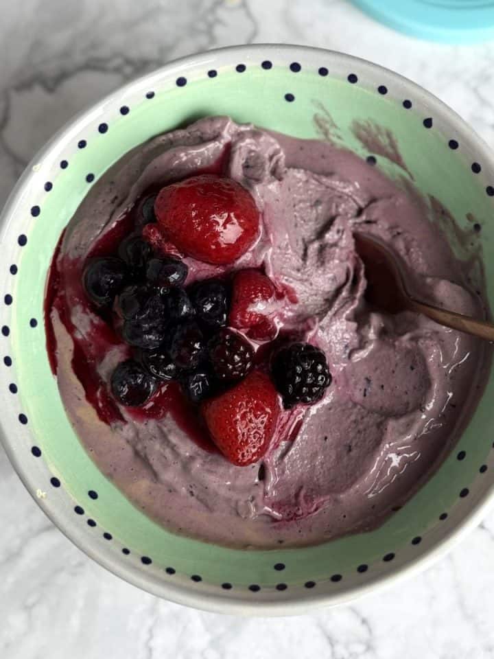 ninja creami chocolate berry breakfast ice cream in a bowl with cherries on top.