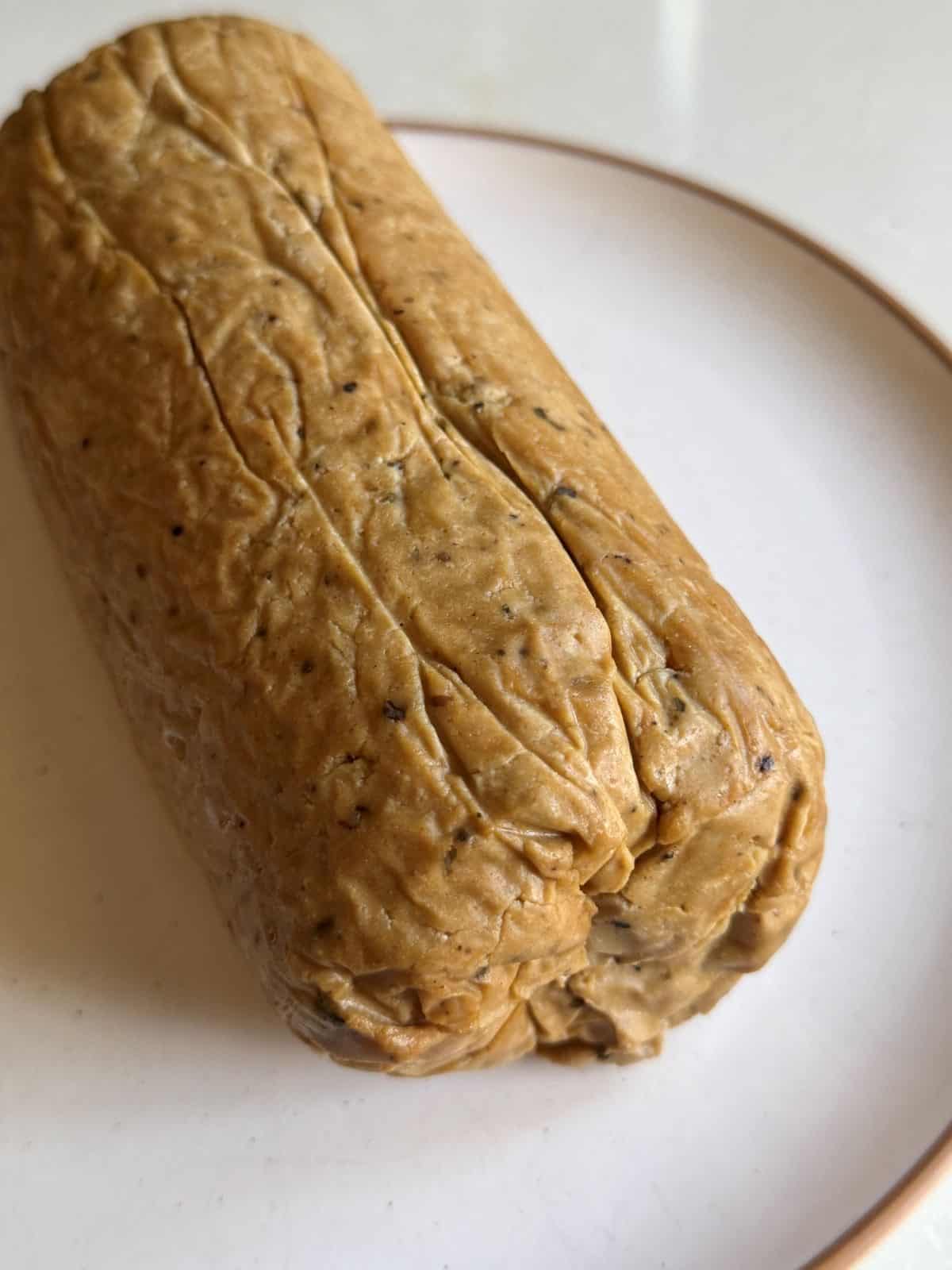 Vegan lunch meat loaf on a white plate.